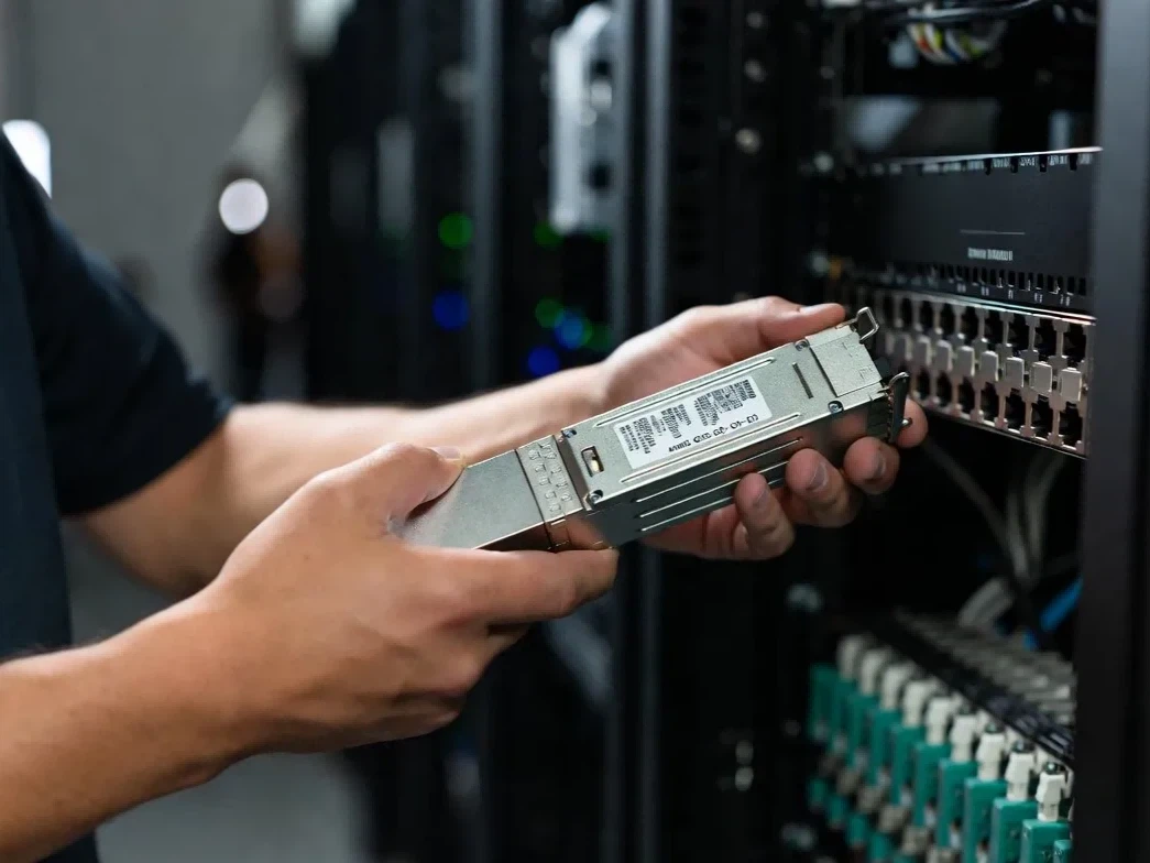 Network technician performing on-site maintenance on a 400G QSFP-DD pluggable transceiver for quick data center link restoration